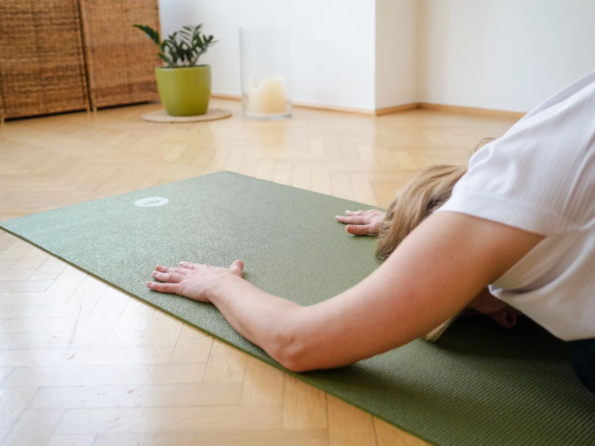 Yogalehrerin in der Asana "das Kind"